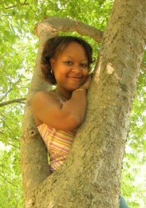 Photo of Patrice, smiling in a tree