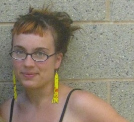 Stephanie Dank, with glasses and long yellow earrings