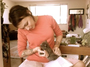 Jasmine in pink shirt holding small kitten