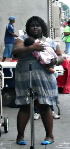 Iresha wearing a dress, holding a baby