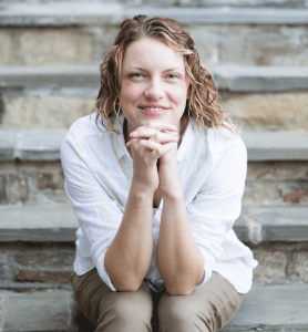 Ashley sitting on the stairs in a white shirt