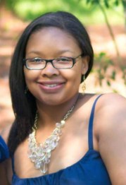 Woman smiling with glasses and a tank top and long hair